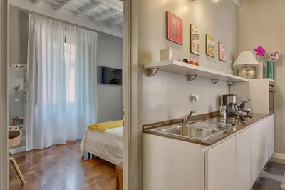 a kitchen with a sink and a bed in a room at RomExperience Borgo Pio in Rome