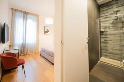 a bathroom with a shower and a bedroom with a bed at Barbra Suite Testaccio in Rome