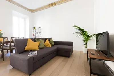 a living room with a gray couch and yellow pillows at Quiet retreat in Trastevere - ZENO 45 in Rome