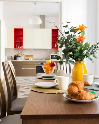 a table with croissants and oranges and a vase of flowers at Quiet retreat in Trastevere - ZENO 45 in Rome