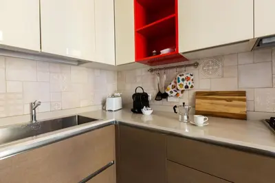 a kitchen with white cabinets and a sink at Quiet retreat in Trastevere - ZENO 45 in Rome