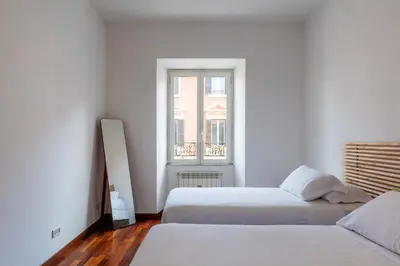 two beds in a white room with a window at Piazza Alessandria - FromHometoRome in Rome