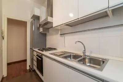 a white kitchen with a sink and a stove at Piazza Alessandria - FromHometoRome in Rome