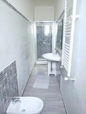 a white bathroom with a sink and a mirror at WelcHomeRome in Rome