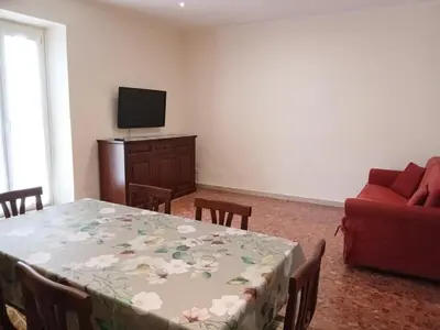 a living room with a table and a red couch at WelcHomeRome in Rome