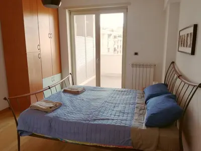 a bedroom with a bed with blue pillows on it at Porta Portese Trastevere Bright New Apartment in Rome