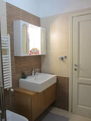 a bathroom with a sink and a mirror at Porta Portese Trastevere Bright New Apartment in Rome
