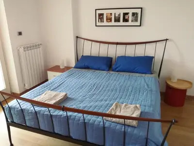 a bed with blue sheets and blue pillows in a room at Porta Portese Trastevere Bright New Apartment in Rome