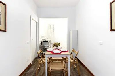 a dining room with a table and chairs at House in the shopping street at Trastevere station in Rome