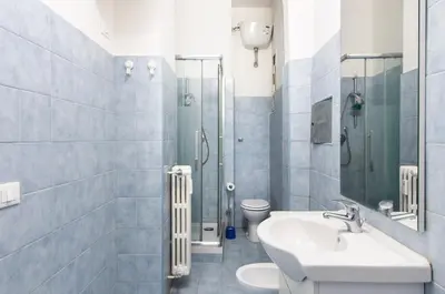 a bathroom with a sink and a toilet and a shower at House in the shopping street at Trastevere station in Rome