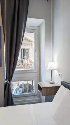 a bedroom with a window with a view of a building at DolceVite - Piazza Di Spagna in Rome