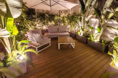 a patio with chairs and an umbrella and plants at DolceVite - Piazza Di Spagna in Rome
