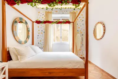 a bedroom with a canopy bed with a window at Funky 3BR Flat, Scenic Tram to Colosseum 7 Stops in Rome