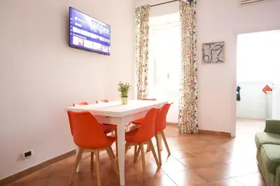 a dining room with a white table and chairs at Funky 3BR Flat, Scenic Tram to Colosseum 7 Stops in Rome