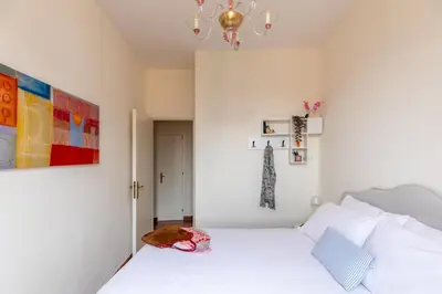 a bedroom with a white bed and a chandelier at iFlat Trevi Charm, Elegant & Comfy Roman Escape in Rome