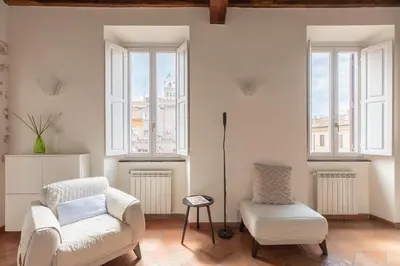 a living room with two chairs and a table and windows at iFlat Trevi Charm, Elegant & Comfy Roman Escape in Rome