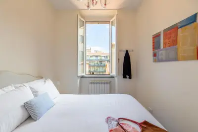 a bedroom with a white bed and a window at iFlat Trevi Charm, Elegant & Comfy Roman Escape in Rome