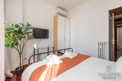a bedroom with a bed and a tv on the wall at Comfy and Elegant Apartment in Rome