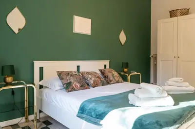 a bedroom with two beds with green walls at Casa Nanna Chic in Vatican in Rome