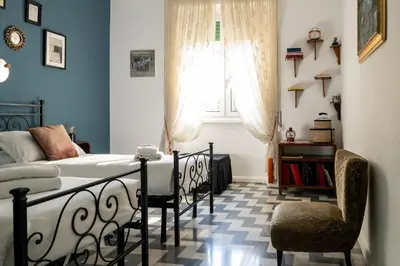 a bedroom with a bed and a window and a chair at Casa Nanna Chic in Vatican in Rome