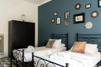 two beds in a room with blue walls at Casa Nanna Chic in Vatican in Rome