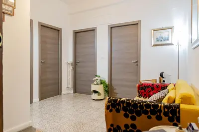 a living room with a yellow couch and three doors at Casa Nanna Chic in Vatican in Rome