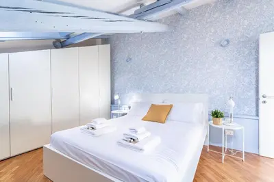 a bedroom with a large white bed with two towels at iFlat Vatican New & Comfy Sunlit Apartment in Rome