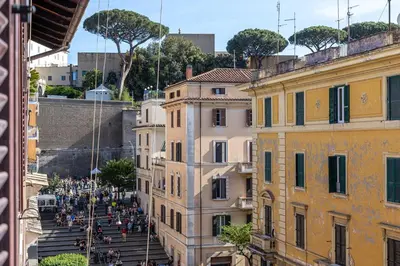 a group of people walking down the street between buildings at iFlat Vatican New & Comfy Sunlit Apartment in Rome