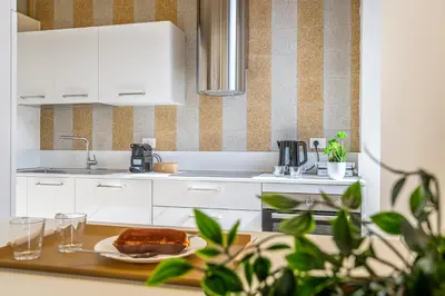 a kitchen with a table with a cake on a plate at iFlat Vatican New & Comfy Sunlit Apartment in Rome