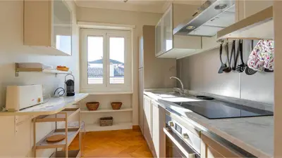 a kitchen with white cabinets and a sink and a window at Vatican Park Residence in Rome