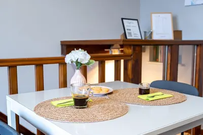 a table with two plates of food and a vase of flowers at Loft16 Rome - 10 min PlGNETO - COLOSSEO in Rome