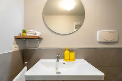 a bathroom with a white sink and a mirror at Loft16 Rome - 10 min PlGNETO - COLOSSEO in Rome