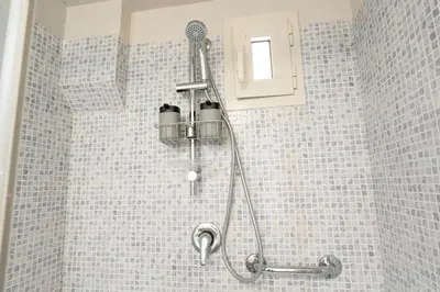 a shower in a bathroom with blue tiles at Loft16 Rome - 10 min PlGNETO - COLOSSEO in Rome