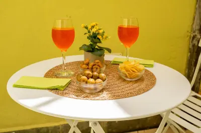 a table with two wine glasses and a bowl of food at Loft16 Rome - 10 min PlGNETO - COLOSSEO in Rome