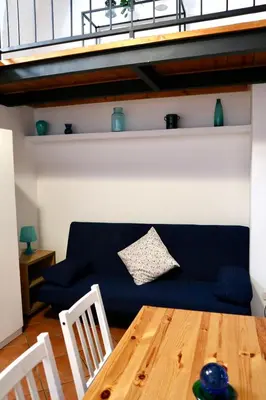 a living room with a blue couch and a wooden table at Loft in Rhome in Rome