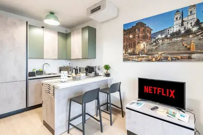 a kitchen with a bar with two stools at Brand new apartment with private parking space in Rome
