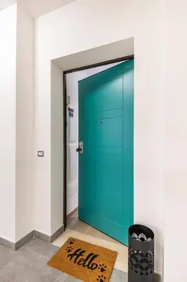 a blue door in a room with a rug at Brand new apartment with private parking space in Rome