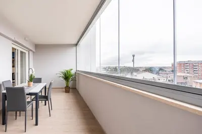 a dining room with a table and a large window at Brand new apartment with private parking space in Rome