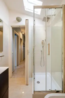 a bathroom with a shower with a glass door at Blue Sky Apartment - 5 min Vatican in Rome