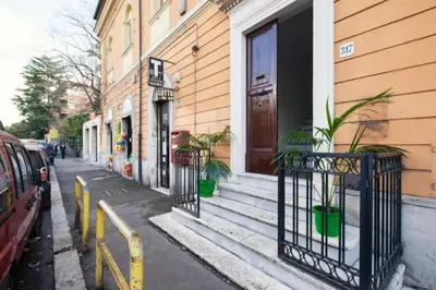 a building with a door and potted plants on a street at Blue Sky Apartment - 5 min Vatican in Rome