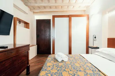 a bedroom with a bed with a dresser and a television at Majorelle comfy apartment in Rome