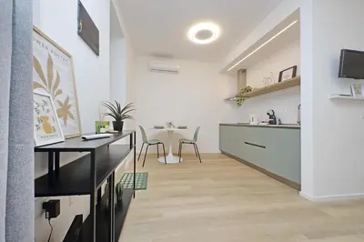 a kitchen and living room with a table and chairs at Charm Apartment San Giovanni in Rome