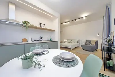 a kitchen and living room with a white table and chairs at Charm Apartment San Giovanni in Rome