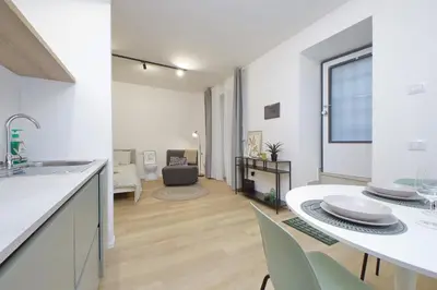 a kitchen and living room with a table and chairs at Charm Apartment San Giovanni in Rome