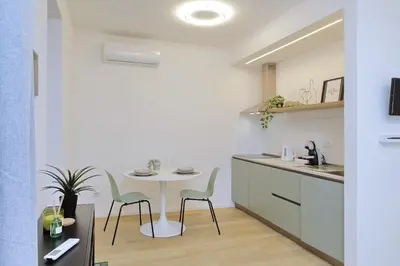 a kitchen with a table and chairs in a room at Charm Apartment San Giovanni in Rome