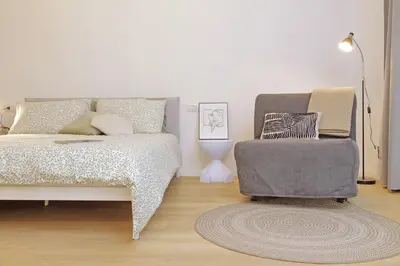 a bedroom with a bed and a chair at Charm Apartment San Giovanni in Rome