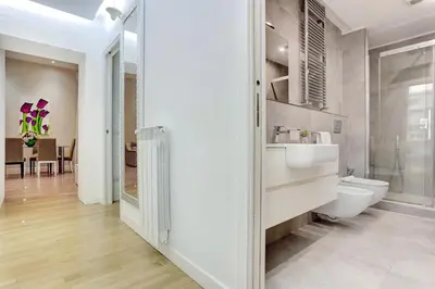 a white bathroom with a toilet and a sink at Porta Pia Suite in Rome