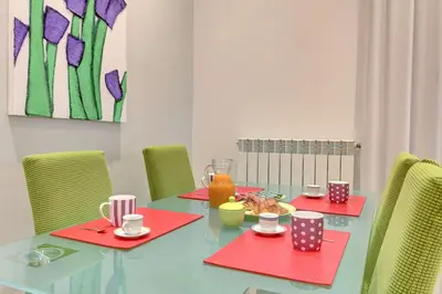 a dining room table with red napkins and chairs at Porta Pia Suite in Rome