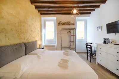 a bedroom with a large white bed and a desk at Trident Suite by BuddyRent in Rome