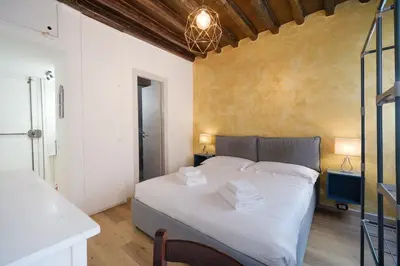 a bedroom with a large bed with white sheets at Trident Suite by BuddyRent in Rome